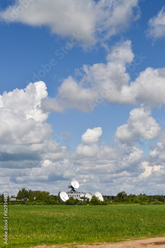 Satellite communication antenna in a field against a blue sky. Space Communication Center