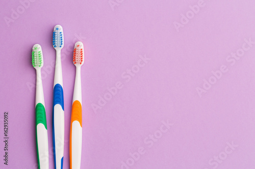 Photo of three colored toothbrushes