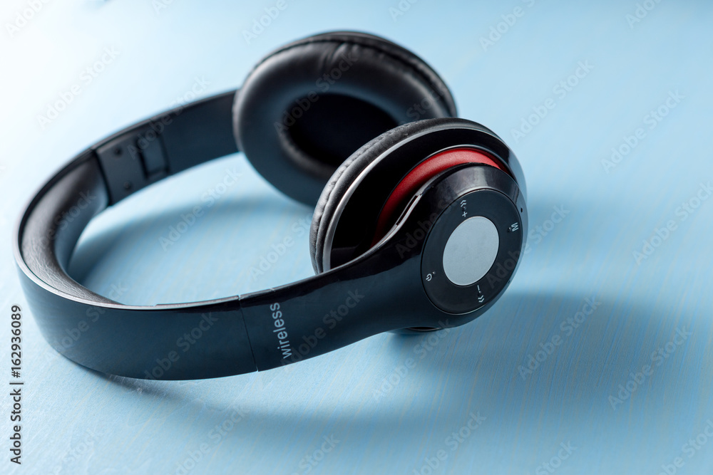 Wireless headphone on blue wooden background