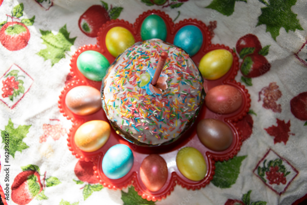 Easter eggs and cake with the candle in the red dish