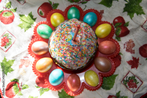 Easter eggs and cake with the candle in the red dish