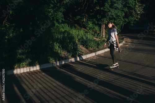 Hipster girl riding skate board
