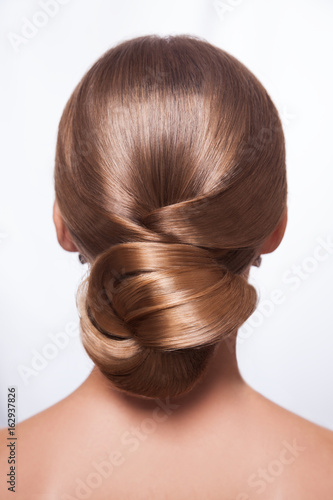 Back view of beautiful woman with creative elegant hairstyle, hair bun. Isolated on white background.