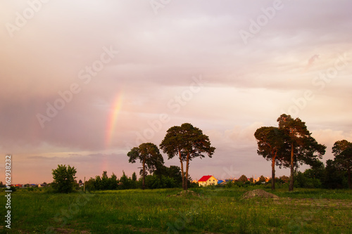 Tyumen, Russia. The rustic landscape with trees, colorful sky and rainbow at the sunset. © Nadezhda Zaitceva
