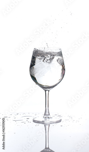 Ice splash in a glass wine of water