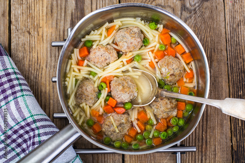 Vermicelli soup with meatballs on wooden background