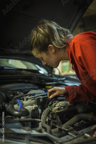 Female mechanic inspecting car engine © tslphoto
