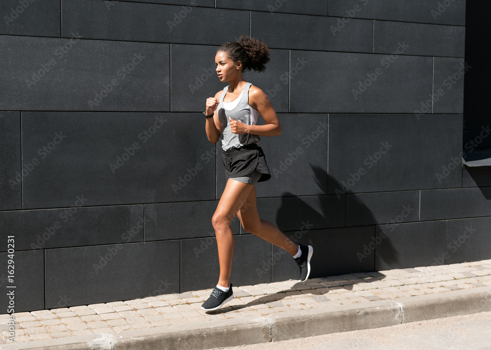 Front view of young jogger, doing cardio workout