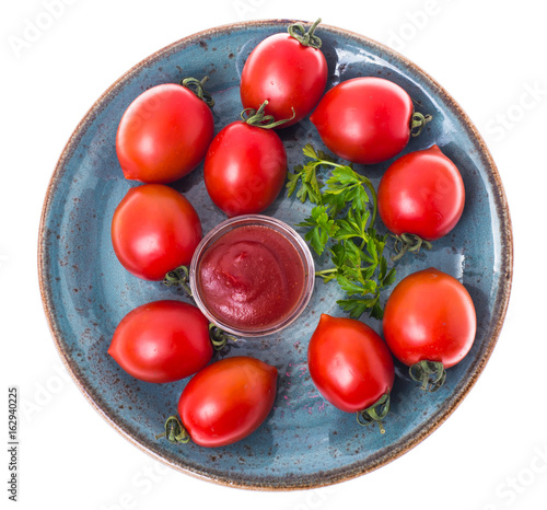 Red ripe tomatoes in salad bowl on white background, top view