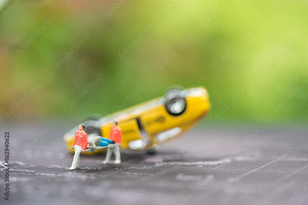 Miniature people, emergency medical team at work at accident scene, car crash, on world map. Concept of health care, emergency, life insurance, accident background Miniature people, emergency medical team at work at accident scene, car crash, on world map. Concept of health care, emergency, life insurance, accident background