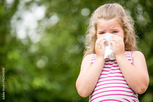 Mädchen mit Grippe beim Nase putzen