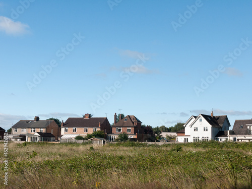 Stock Photo - back of houses in a field in summer light wivenhoe essex england uk