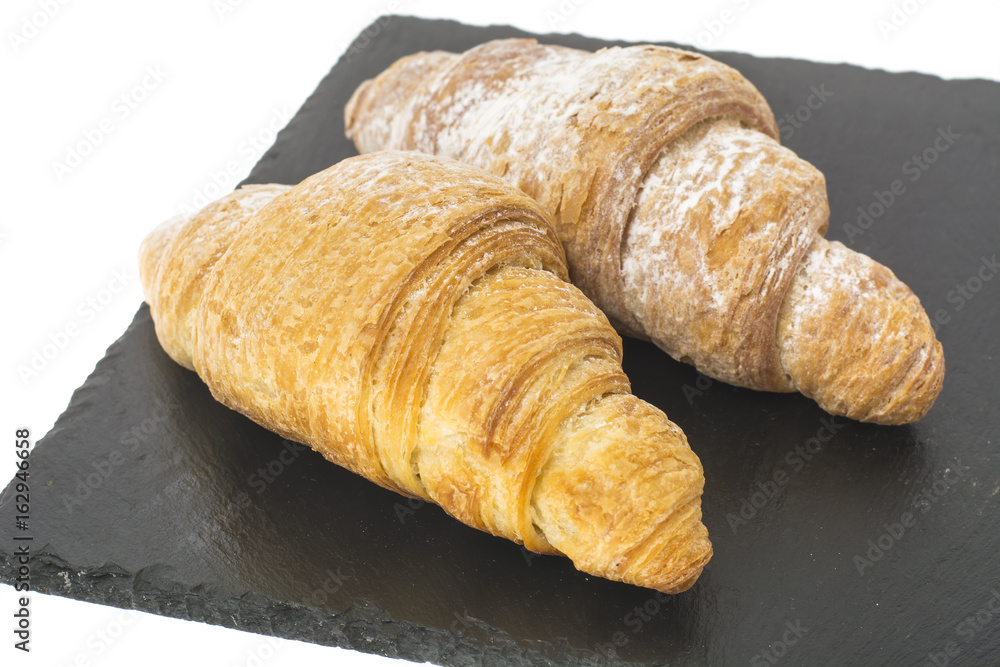 Two croissants on plate on white background. 