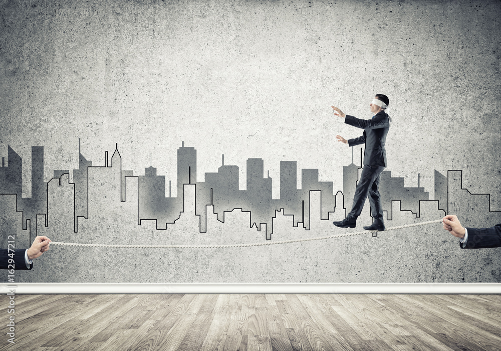 Business concept of risk support and assistance with man balancing on rope Business concept of risk support and assistance with man balancing on rope