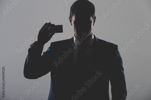 Vászonkép silhouette of man holding business or bank card