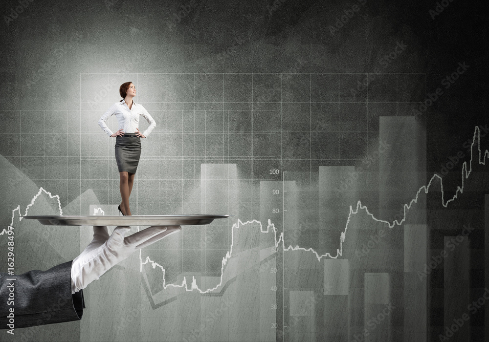 Confident elegant businesswoman presented on metal tray and graphs at background Confident elegant businesswoman presented on metal tray and graphs at background