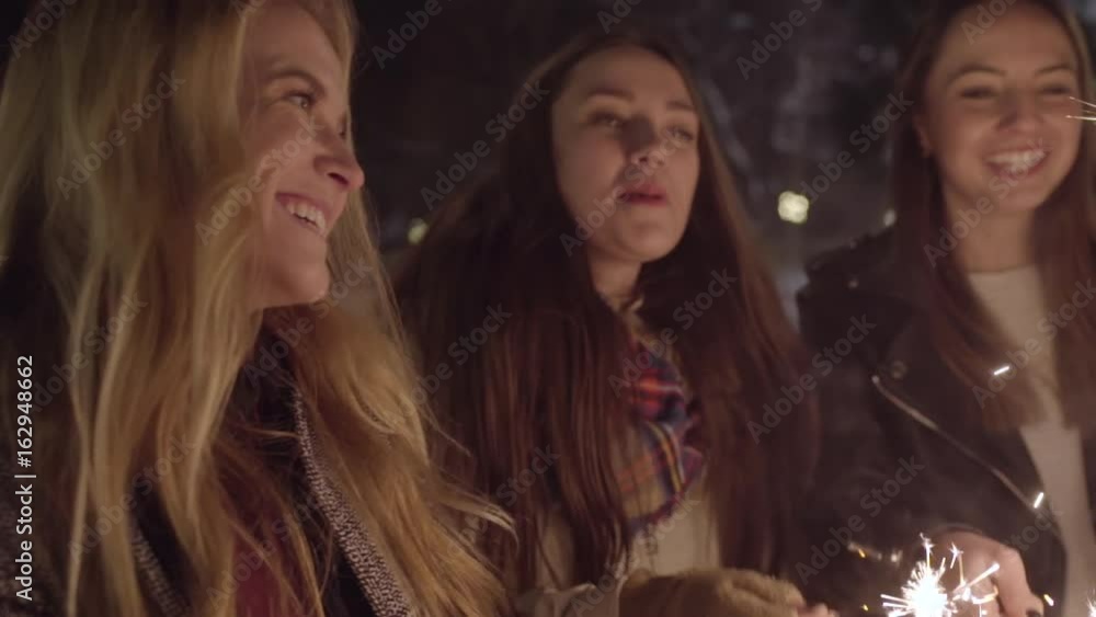 Closeup Of Happy Young Women Dancing With Sparklers At Night In Winter Closeup Of Happy Young Women Dancing With Sparklers At Night In Winter