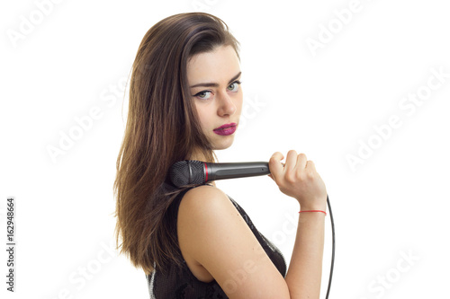 Portrait of sexual young girl with microphone in hand isolated on white background