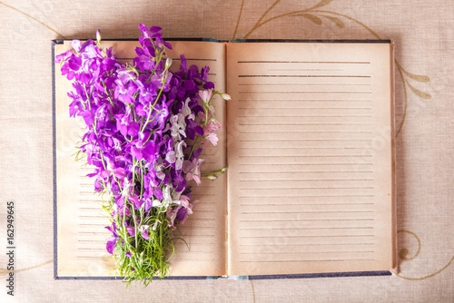 Bouquet of lilac flowers on a notebook top view