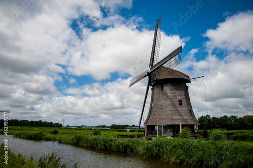 Dutch windmill with cloudy sky in the summer © arjenschippers