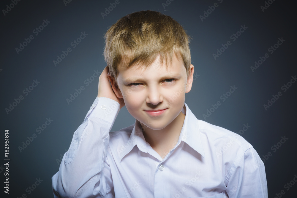 doubt, expression and people concept - boy thinking over gray background doubt, expression and people concept - boy thinking over gray background