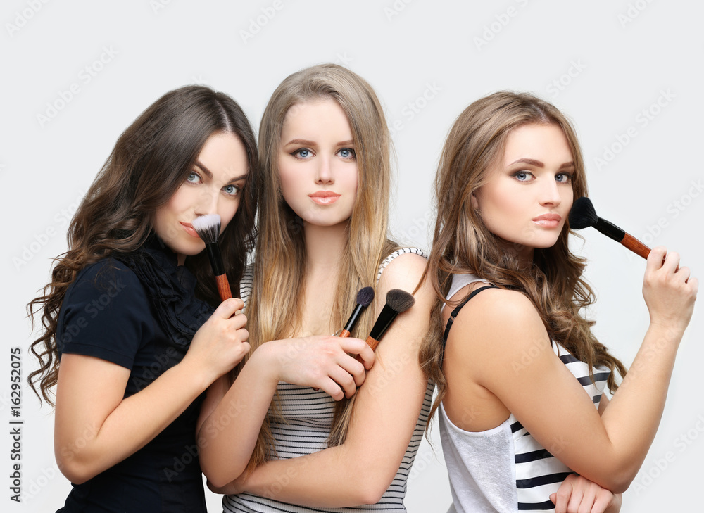 Applying Make-up. Woman with a brush for make-up.Female friends putting makeup Applying Make-up. Woman with a brush for make-up.Female friends putting makeup
