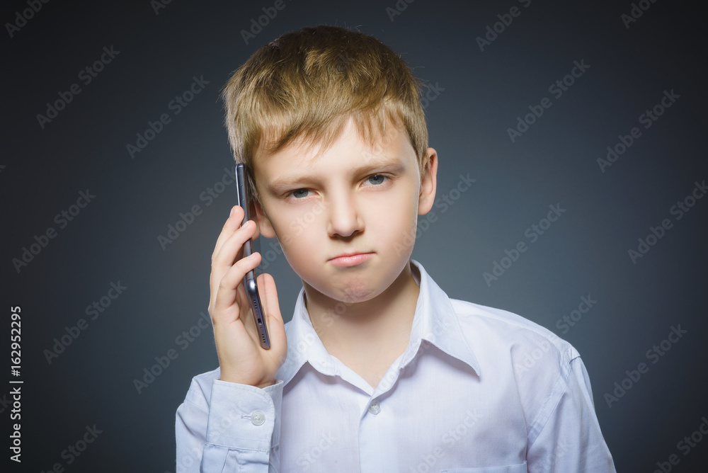 Portrait of offense boy with mobile or cell phone. Negative human emotion Portrait of offense boy with mobile or cell phone. Negative human emotion