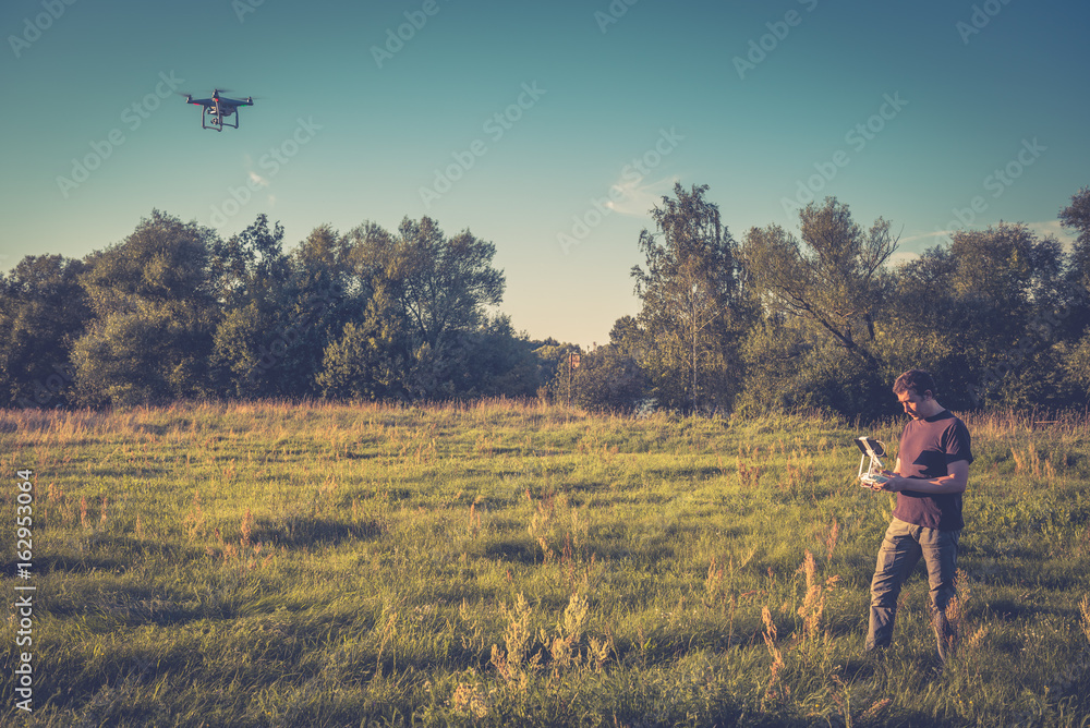 © scaliger - Man operating a drone quad copter