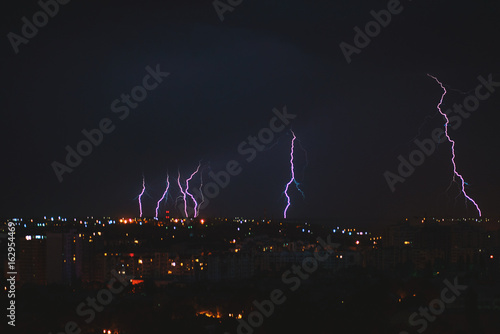 Fotografie Photo of beautiful powerful lightning over big city, zipper and thunderstorm, ab