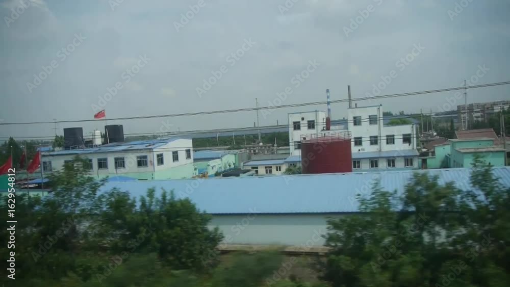 Oil tank chemical plants in rural countryside.Speeding train travel,scenery outside window. Oil tank chemical plants in rural countryside.Speeding train travel,scenery outside window.