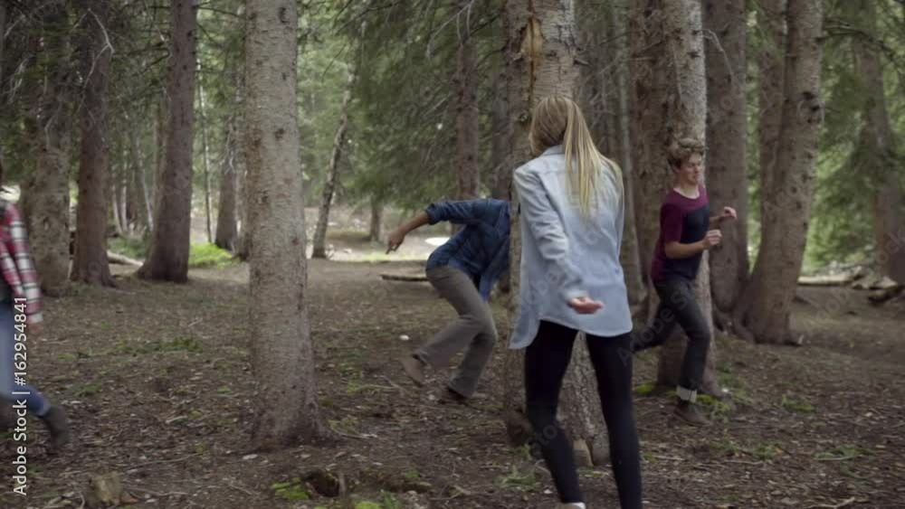 Group Of Fun Teens Play A Game Of Tag In A Forest (Slow Motion) Group Of Fun Teens Play A Game Of Tag In A Forest (Slow Motion)