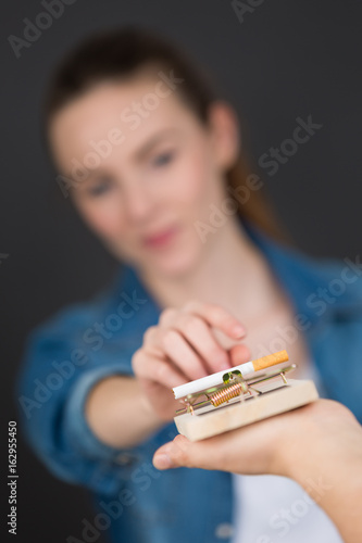 фотографія antismoking background with broken cigarettes in a trap
