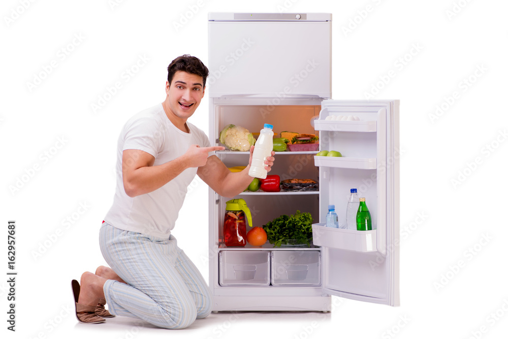 Man next to fridge full of food Man next to fridge full of food