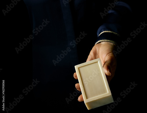 woman hand isolated on black showing bar of soap