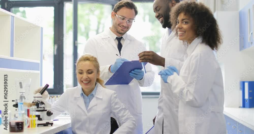 Cheerful Group Of Scientists Discussing Results Of Successful Experiment Discovery In Laboratory Happy Smiling Mix Race Team Slow Motion 60 Cheerful Group Of Scientists Discussing Results Of Successful Experiment Discovery In Laboratory Happy Smiling Mix Race Team Slow Motion 60