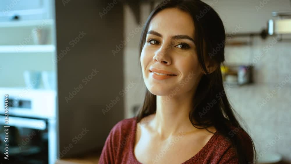 Woman portrait close up. Beautiful woman looking at the camera and smiling in the kitchen at home Woman portrait close up. Beautiful woman looking at the camera and smiling in the kitchen at home