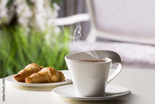 Fototapeta Naklejka Na Ścianę i Meble -  Coffee in a white mug on the background of the hotel interior