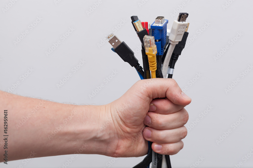 Hand holding out a bunch of computer cables with different connectors  Stock-Foto | Adobe Stock