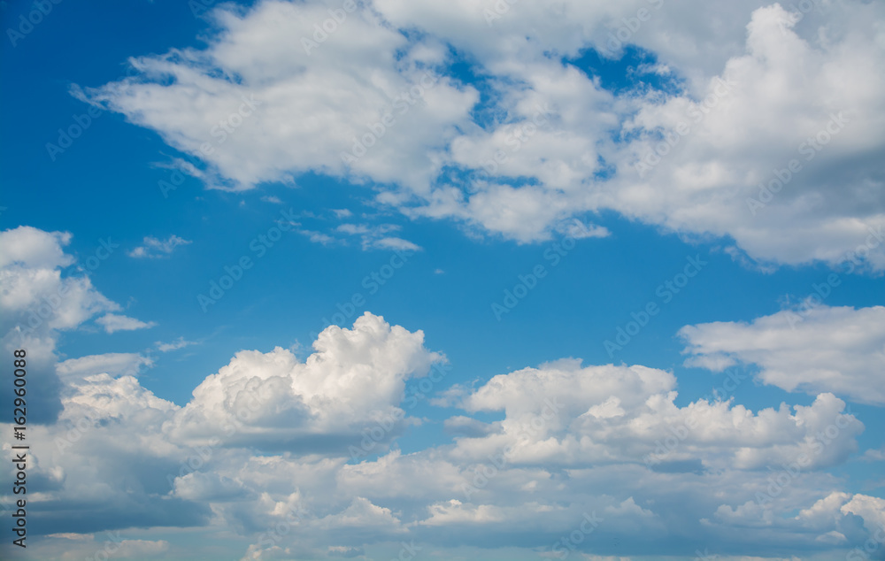 White curly clouds in a blue sky. Sky background White curly clouds in a blue sky. Sky background