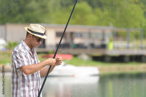 man near the lake prepares for fishing tackle