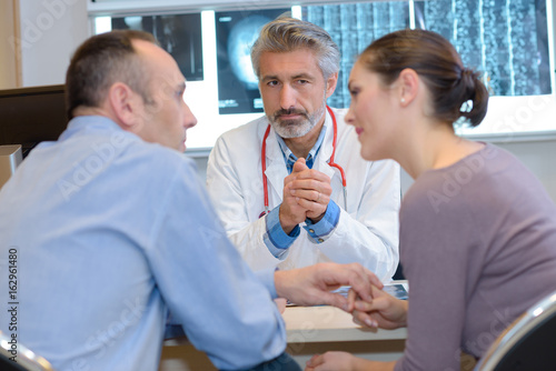 Fotografie gynecologist talking to couple and options to conceive