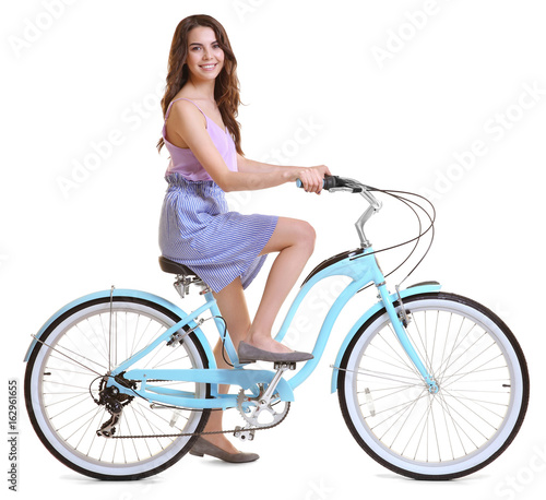 Fototapeta Naklejka Na Ścianę i Meble -  Beautiful young woman riding bicycle on white background