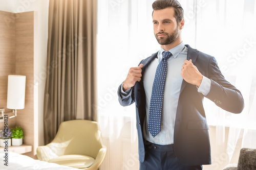 Slika na platnu Young man business traveler hotel room accomodation