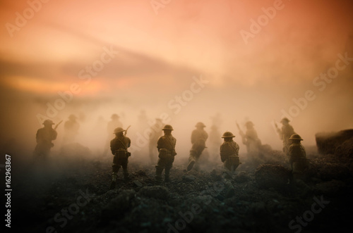 War Concept. Military silhouettes fighting scene on war fog sky background, World War Soldiers Silhouettes Below Cloudy Skyline At night. Attack scene. Armored vehicles. Tanks battle