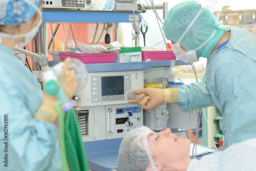 surgeons working with monitoring of patient in surgical operating room