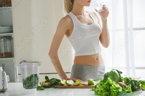 Young woman making detox smoothie at home photo