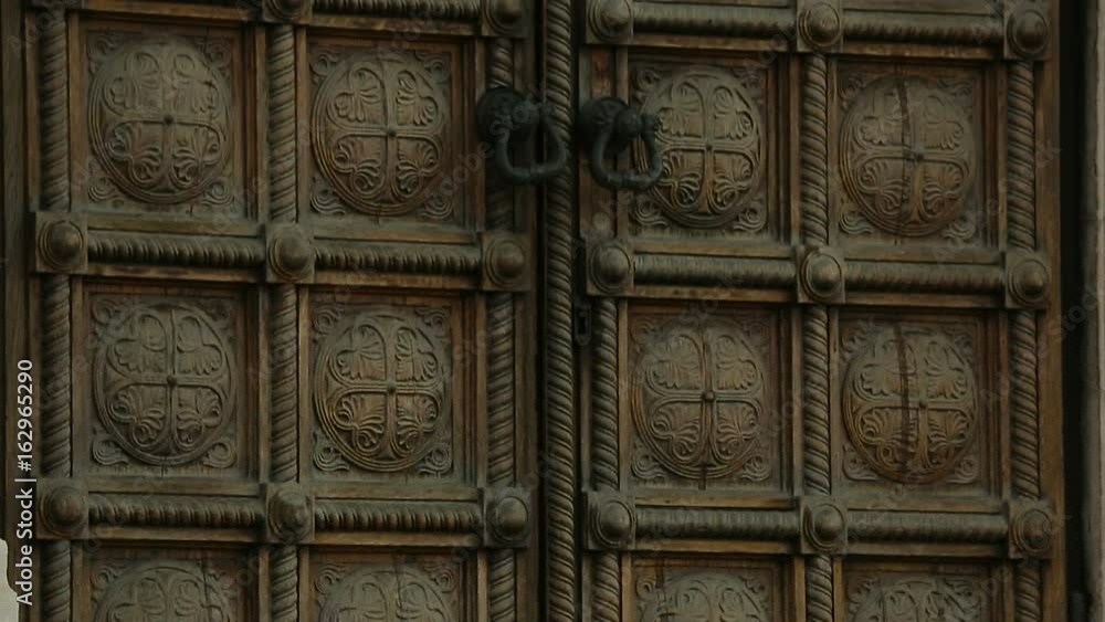 Double ancient doors with carving and massive handles, architecture, entrance Double ancient doors with carving and massive handles, architecture, entrance
