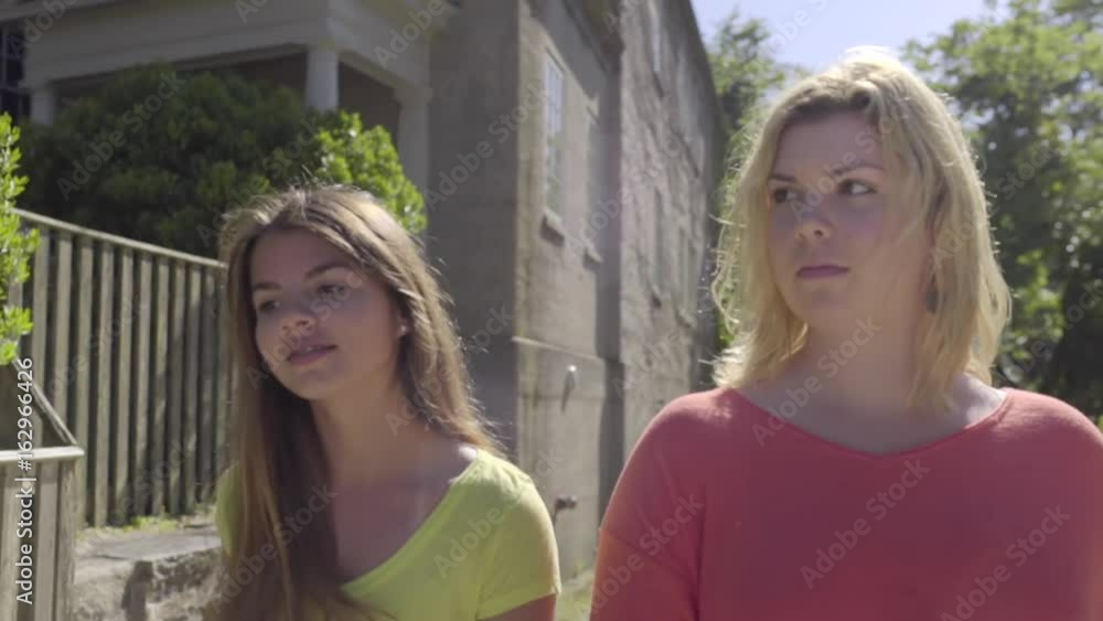 Two Teenage Girls Talk And Walk Around New England Neighborhood In Summer (Slow Motion) Two Teenage Girls Talk And Walk Around New England Neighborhood In Summer (Slow Motion)