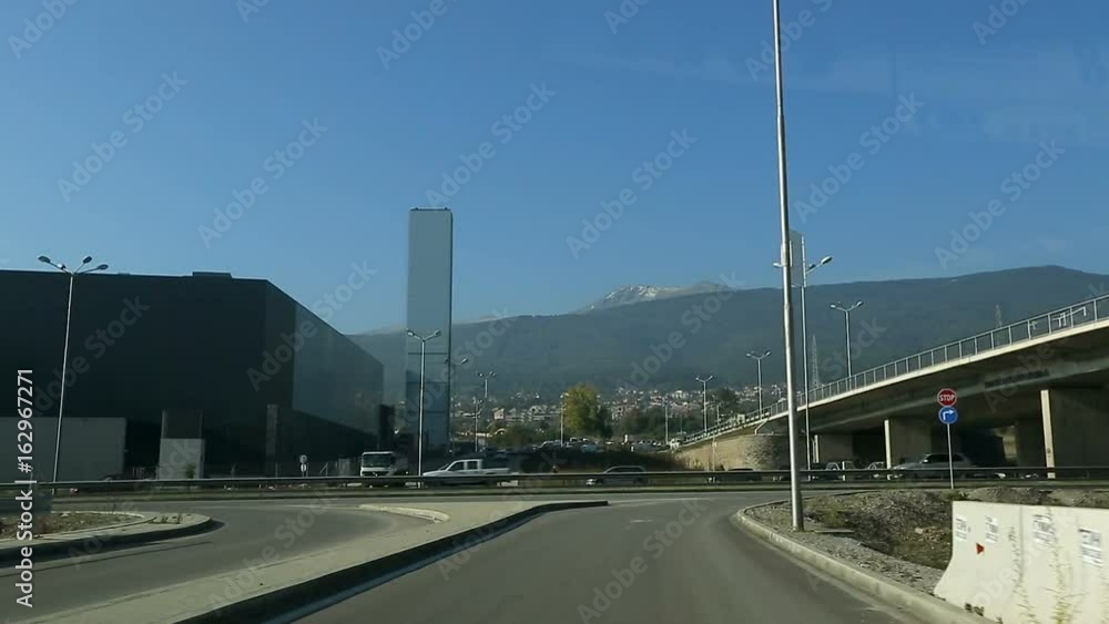 Car going down motorway, big city against mountains in front, communication Car going down motorway, big city against mountains in front, communication