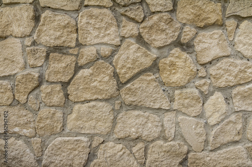 Stone wall background. Rock textured surface. Rough material. Horizontal view